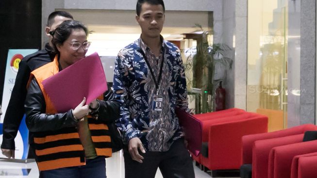 Tersangka mantan anggota Bawaslu Agustiani Tio Fridelina mengenakan rompi tahanan usai menjalani pemeriksaan di gedung KPK, Jakarta, Jumat (10/1) dini hari.[Suara.com/Alfian Winanto]
