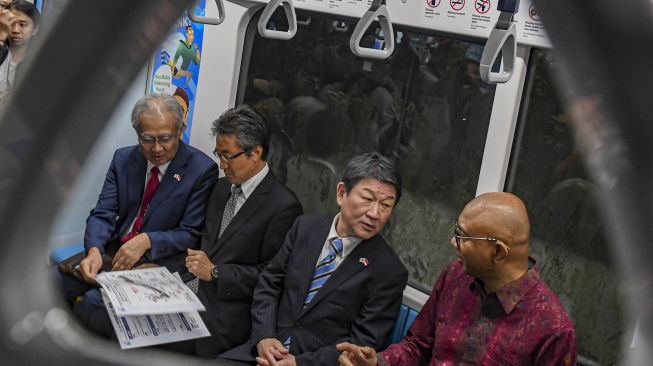 Menteri Luar Negeri Jepang Toshimitsu Motegi (kedua kanan) berbincang bersama Direktur Utama PT MRT Jakarta William P Sabandar (kanan), Duta Besar Jepang untuk RI Masafumi Ishii (kiri) dan Chief Representative JICA Indonesia Yamanaka Shinichi (kedua kanan) saat menumpang kereta MRT di Jakarta, Jumat (10/1). [ANTARA FOTO/Muhammad Adimaja]