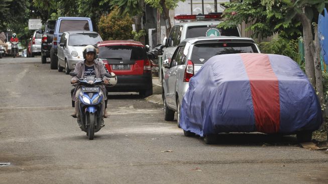 Mobil diparkir dipinggir jalan di Pancoran Mas, Depok, Jawa Barat, Sabtu (11/1). [ANTARA FOTO/Asprilla Dwi Adha]
