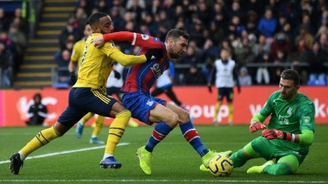 Kiper Arsenal Bernd Leno menggagalkan peluang yang dimiliki pemain Crystal Palace James McArthur dalam pertandingan Liga Inggris yang berlangsung di Selhurst Park, Sabtu (11/1/2020). [AFP]