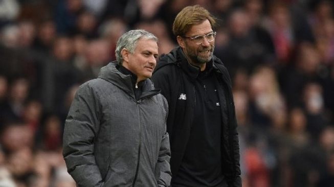 Jurgen Klopp dan Jose Mourinho berbincang di pinggir lapangan di pertandingan Liga Inggris musim 2017/18. [AFP]