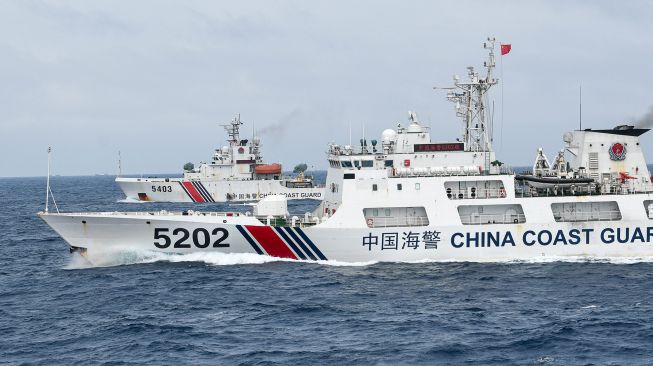 Kapal Coast Guard China-5202 dan Coast Guard China-5403 membayangi KRI Usman Harun-359 saat melaksanakan patroli mendekati kapal nelayan pukat China yang melakukan penangkapan ikan di ZEE Indonesia Utara Pulau Natuna, Sabtu (11/1). [ANTARA FOTO/M Risyal Hidayat]