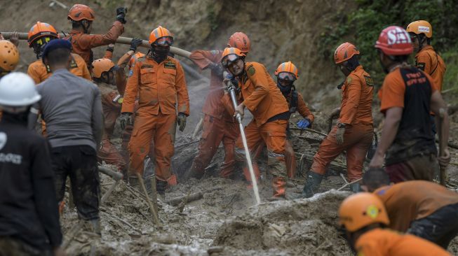 Anggota tim SAR gabungan menggunakan alat penyemprot air untuk melakukan pencarian korban tanah longsor dan banjir bandang yang masih belum ditemukan di Kampung Sinar Harapan, Desa Harkat Jaya, Kecamatan Sukajaya, Kabupaten Bogor, Jawa Barat, Sabtu (11/1). [ANTARA FOTO/Galih Pradipta]