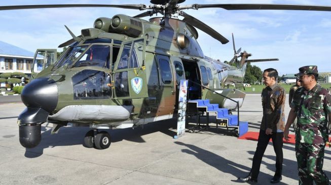 Presiden Joko Widodo (kiri) didampingi Panglima TNI Marsekal TNI Hadi Tjahjanto (kanan) meninjau Helikopter berjenis EC-725 AP/Caracal milik TNI AU sebelum bertolak ke Abu Dhabi, Uni Emirat Arab dari Pangkalan TNI AU Halim Perdanakusuma, Jakarta, Minggu (12/1). [ANTARA FOTO/HO/Setpres-Laily Rachev]