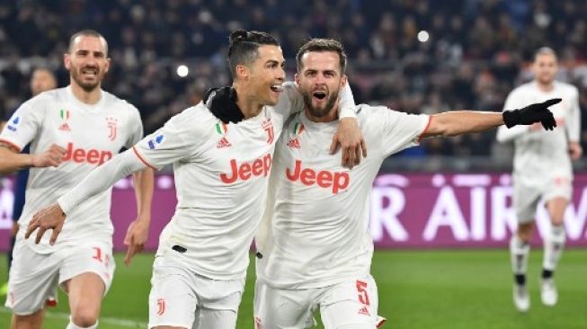 Bintang Juventus Cristiano Ronaldo merayakan golnya ke gawang AS Roma dari titik penalti bersama Miralem Pjanic saat laga Liga Italia di Olympico stadium. Tiziana FABI / AFP