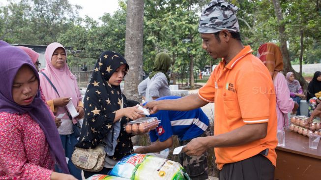 Aktivitas warga berbelanja pangan murah di RPTRA Ranggon Kusuma Baru, Pondok Ranggon, Jakarta Timur, Selasa (14/01). [Suara.com/Alfian Winanto]
