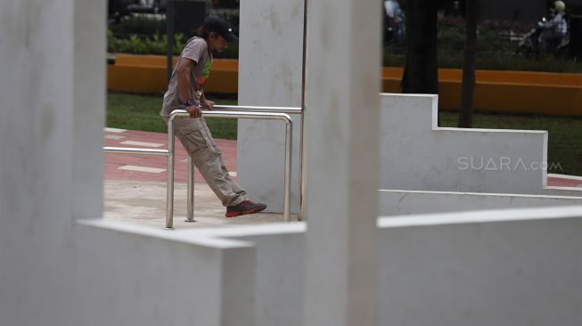 Seorang warga berolahraga di kawasan Taman Puring, Kebayoran Baru, Jakarta Selatan, Selasa (14/1). [Suara.com/Angga Budhiyanto]