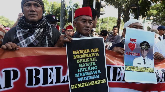 Sejumlah massa yang pro terhadap Gubernur Anies Baswedan melakukan aksi unjuk rasa di kawasan Monumen Nasional (Monas), Jakarta, Selasa (14/1). [Suara.com/Angga Budhiyanto]
