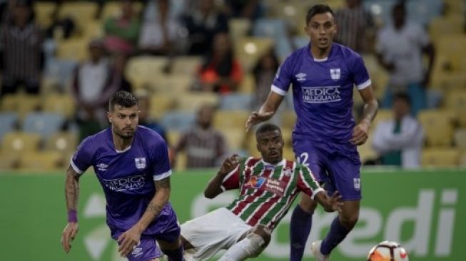 Calon pemain Arema FC, Santiago Carrera (kiri bawah) saat membela Defensor Sporting di Liga Uruguay. (PABLO PORCIUNCULA / AFP)