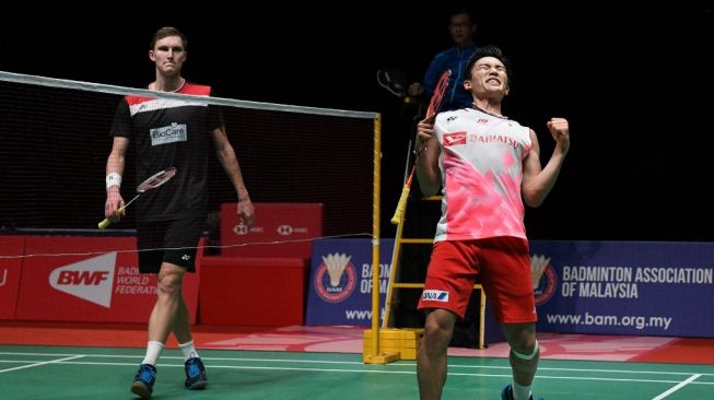 Pebulutangkis tunggal putra Jepang, Kento Momota (kanan), meluapkan kegembiraan usai memastikan diri menjuarai Malaysia Masters 2020 dengan mengalahkan Viktor Axelsen (kiri) di Axata Arena, Kuala Lumpur, Minggu (12/1/2020). [AFP/Mohd Rasfan]