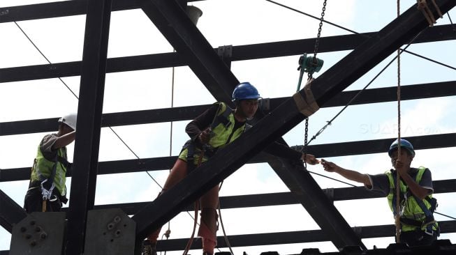 Pekerja menyelesaikan proyek jembatan layang integrasi antara Stasiun MRT ASEAN dengan Halte Centrale Stichting Wederopbouw (CSW) koridor 13 di Jakarta, Selasa (14/1). [Suara.com/Angga Budhiyanto]