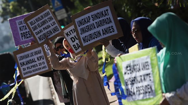 Sejumlah massa yang pro terhadap Gubernur Anies Baswedan melakukan aksi unjuk rasa di kawasan Monumen Nasional (Monas), Jakarta, Selasa (14/1). [Suara.com/Angga Budhiyanto]
