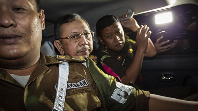 Mantan Direktur Utama PT Asuransi Jiwasraya Hendrisman Rahim (tengah) berada di dalam mobil tahanan usai menjalani pemeriksaan di gedung Jampidsus Kejaksaan Agung, Jakarta, Selasa (14/1). [ANTARA FOTO/Dhemas Reviyanto]
