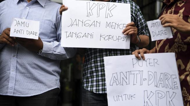 Sejumlah pegiat antikorupsi yang tergabung dalam koalisi masyarakat sipil menggelar aksi sebelum menyerahkan jamu antidiare di gedung KPK, Jakarta, Rabu (15/1). [ANTARA FOTO/Hafidz Mubarak] 
