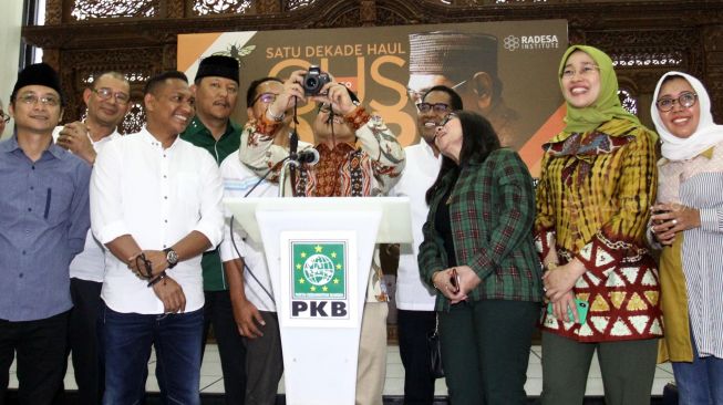 Ketua Umum PKB Muhaimin Iskandar memotret saat membuka pameran foto satu dekade haul Gus Dur di di kantor DPP PKB, Jakarta, Rabu (15/1). [Suara.com/Oke Atmaja]
