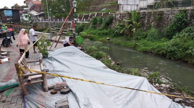 Sejumlah warga mengecek keadaan talut longsor sepanjang 6 meter di Kampung Serangan, Kelurahan Notoprajan, Kecamatan Ngampilan, Kota Yogyakarta, Kamis (16/1/2020). - (Suara.com/Baktora)