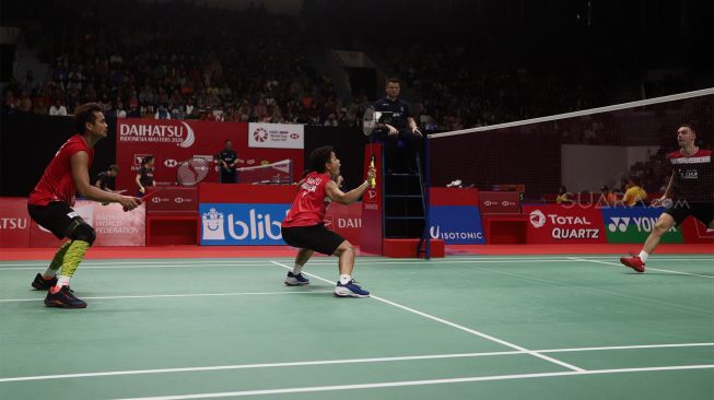 Pasangan Ganda Campuran Indonesia Tontowi Ahmad dan Apriyani Rahayu mengembalikan shuttle kok ke arah Pasangan Ganda Campuran Inggris Chris Adcock dan Gabrielle Adcock dalam babak kedua Daihatsu Indonesia Master 2020 di Istora Senayan, Jakarta, Kamis (16/1).[Suara.com/Angga Budhiyanto]