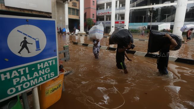 Pedagang beraktivitas saat banjir merendam Pasar Cipulir, Jakarta Selatan, Rabu (1/1). [Suara.com/Angga Budhiyanto]