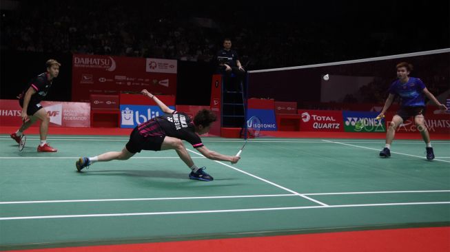 Pebulu tangkis ganda putra Indonesia Marcus Fernaldi Gideon dan rekannya Kevin Sanjaya Sukamuljo mengembalikan kok ke arah lawannya asal Malaysia Aaron Chia dan Soh Wooi Yik dalam babak semifinal Daihatsu Indonesia Masters 2020 di Istora Senayan, Jakarta, Sabtu (18/1). [Suara.com/Angga Budhiyanto]