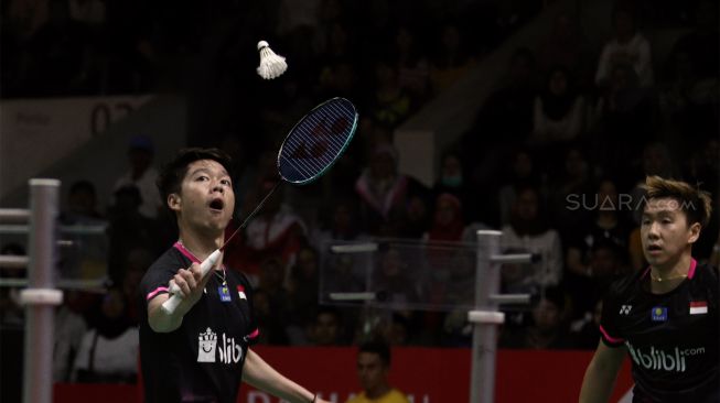 Pebulu tangkis ganda putra Indonesia Marcus Fernaldi Gideon dan rekannya Kevin Sanjaya Sukamuljo mengembalikan kok ke arah lawannya asal Malaysia Aaron Chia dan Soh Wooi Yik dalam babak semifinal Daihatsu Indonesia Masters 2020 di Istora Senayan, Jakarta, Sabtu (18/1). [Suara.com/Angga Budhiyanto]