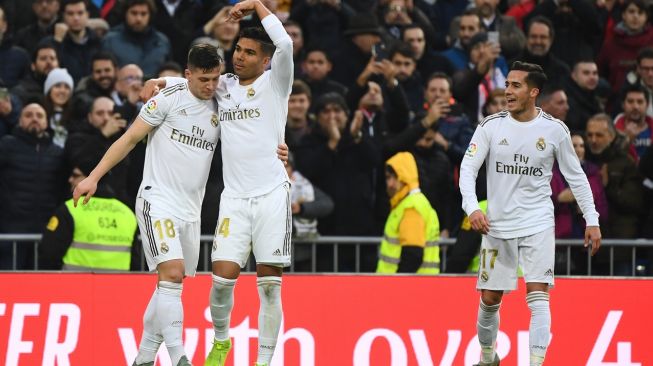 Pemain Real Madrid, Casemiro (tengah), merayakan gol ke gawang Sevilla bersama rekannya Luka Jovic (kiri) dan Lucas Vazquez, dalam laga lanjutan La Liga Spanyol, Sabtu (18/1/2020). [GABRIEL BOUYS / AFP]