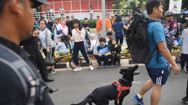 Anjing pelacak dari Unit K-9 Polri mengendus adanya bom yang dibawa oleh seseorang di dalam tasnya saat simulasi di kawasan hari bebas kendaraan bermotor atau car free day (CFD) di Jalan MH Thamrin, Jakarta, Minggu (19/1).  [ANTARA FOTO/Akbar Nugroho Gumay]
