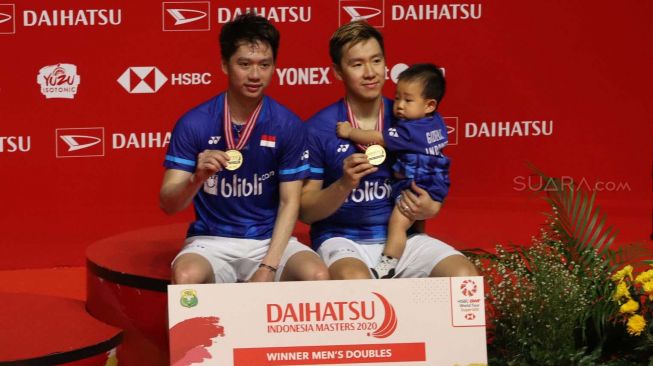 Pebulu tangkis ganda putra Indonesia Kevin Sanjaya Sukamuljo (kiri) dan rekannya Marcus Fernaldi Gideon memegang medali usai mengalahkan lawan senegara Hendra Setiawan dan Mohammad Ahsan dalam pertandingan babak final Daihatsu Indonesia Masters 2020 di Istora Senayan, Jakarta, Minggu (19/1). [Suara.com/Alfian Winanto]