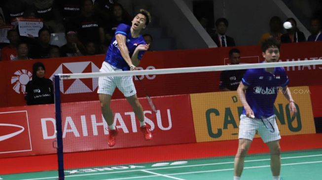 Pebulu tangkis ganda putra Indonesia Kevin Sanjaya Sukamuljo (kanan) dan rekannya Marcus Fernaldi Gideon mengembalikan kok ke arah lawan senegara Hendra Setiawan dan Mohammad Ahsan dalam pertandingan babak final Daihatsu Indonesia Masters 2020 di Istora Senayan, Jakarta, Minggu (19/1).[Suara.com/Alfian Winanto]
