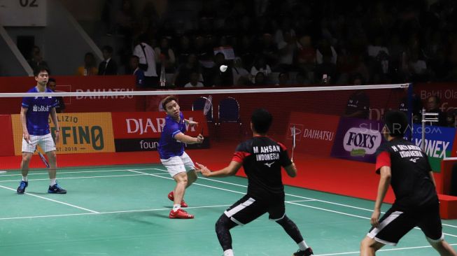 Pebulu tangkis ganda putra Indonesia Kevin Sanjaya Sukamuljo (kanan) dan rekannya Marcus Fernaldi Gideon mengembalikan kok ke arah lawan senegara Hendra Setiawan dan Mohammad Ahsan dalam pertandingan babak final Daihatsu Indonesia Masters 2020 di Istora Senayan, Jakarta, Minggu (19/1).[Suara.com/Alfian Winanto]
