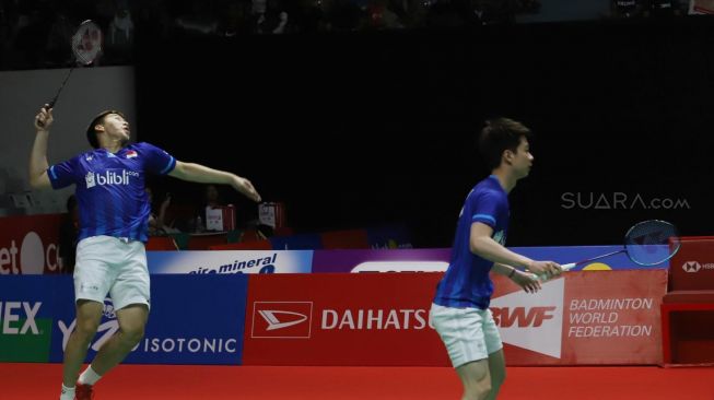 Pebulu tangkis ganda putra Indonesia Kevin Sanjaya Sukamuljo (kanan) dan rekannya Marcus Fernaldi Gideon mengembalikan kok ke arah lawan senegara Hendra Setiawan dan Mohammad Ahsan dalam pertandingan babak final Daihatsu Indonesia Masters 2020 di Istora Senayan, Jakarta, Minggu (19/1).[Suara.com/Alfian Winanto]
