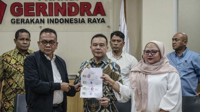 Ketua DPD Gerindra DKI Jakarta Muhammad Taufik (kiri) bersama Waketum DPP Gerindra Sufmi Dasco Ahmad (tengah), dan Ketua Fraksi Gerindra DPRD DKI Jakarta Rany Maulani (kanan), menunjukkan dokumen seusai memberikan keterangan pers tentang nama calon Wakil Gubernur (cawagub) DKI Jakarta di Kantor Fraksi Gerindra DPRD DKI Jakarta, Senin (20/1).  [ANTARA FOTO/Aprillio Akbar]