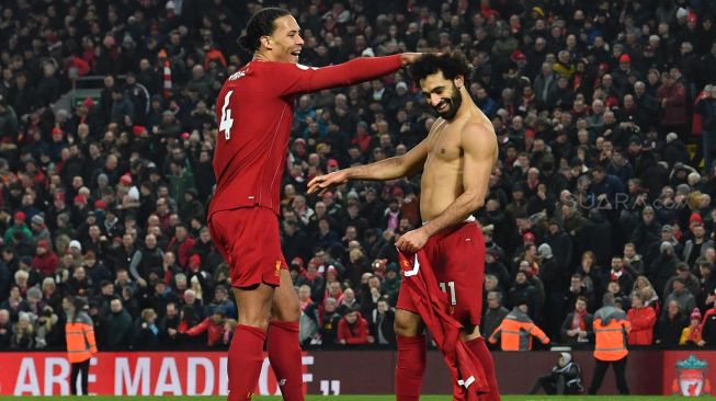 Penyerang Liverpool Mohamed Salah merayakan gol kedua mereka dengan bek Liverpool Virgil van Dijk (kiri) selama pertandingan sepak bola Liga Primer Inggris antara Liverpool melawan Manchester United di sStadion Anfield, Liverpool, Inggris, Minggu (19/1). [Paul ELLIS / AFP]
