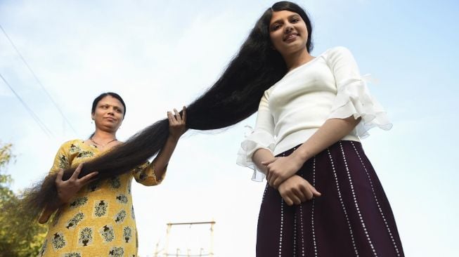 Gadis asal India Nilanshi Patel berpose dengan ibunya, di kota Modasa, sekitar 110 km dari Ahmedabad, India, Minggu (19/1). [SAM PANTHAKY / AFP]