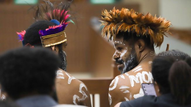 Dua tapol Papua kasus pengibaran bendera bintang kejora mengenakan koteka saat menghadiri sidang lanjutan dengan agenda jawaban Jaksa atas eksepsi penasihat hukum, di Pengadilan Negeri Jakarta Pusat, Senin (20/01). [Suara.com/Alfian Winanto]