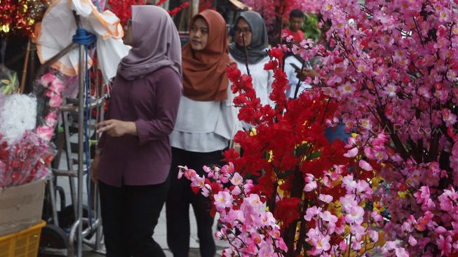 Calon pembeli melihat pohon bunga Meihua yang dijual di toko di kawasan pasar Asemka, Jalan Pintu Kecil, Jakarta Barat, Selasa (21/1). [Suara.com/Angga Budhiyanto]