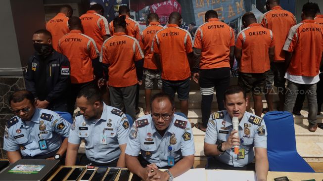 Kepala Imigrasi Jakarta Barat Noviyanto Sulastono (kedua kanan) bersama jajarannya memberikan keterangan kepada awak media saat rilis penangkapan orang asing di Kantor Imigrasi Jakarta Barat, Jakarta, Selasa (21/1). [Suara.com/Angga Budhiyanto]
