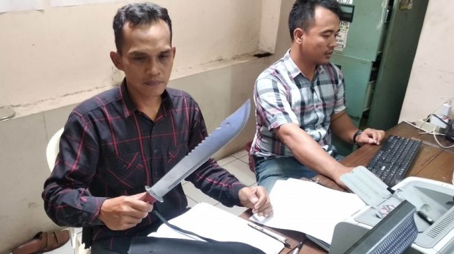 Petugas Polsek Umbulharjo menunjukkan barang bukti berupa pedang milik orang mabuk yang membuat resah warga di Kampung Ponggalan, Kelurahan Giwangan, Kecamatan Umbulharjo, Kota Yogyakarta Selasa (21/1/2020). - (Suara.com/Baktora)