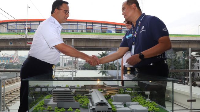 Gubernur DKI Jakarta Anies Baswedan dan Direktur Utama PT Transjakarta yang berjabat tangan saat peresmian pencanangan Groundbreaking Halte Transjakarta Centrale Stitching Wederoupbouw (CSW) di stasiun MRT Asean, Jakarta Selatan, Rabu (22/01). [Suara.com/Alfian Winanto]
