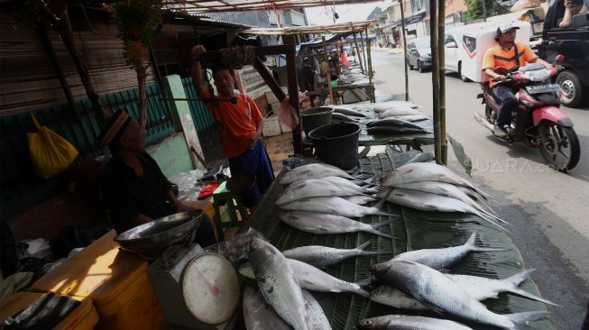 Pedagang berada di lapaknya di Pasar Rawa Belong, Jakarta Barat, Rabu (22/1). [Suara.com/Angga Budhiyanto]