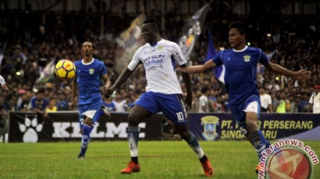 Striker Persib Bandung Ezechiel Ndouassel (tengah) dihadang dua gelandang Perserang FC Junaedi (kanan) dan Okto Nanda (kiri) saat bermain pada Laga Persahabatan kedua klub di Stadion Maulana Yusuf Serang, Banten, Kamis (1/3/2018). Persib memenangi pertandingan dengan skor 6-0. (ANTARA/Asep Fathulrahman)