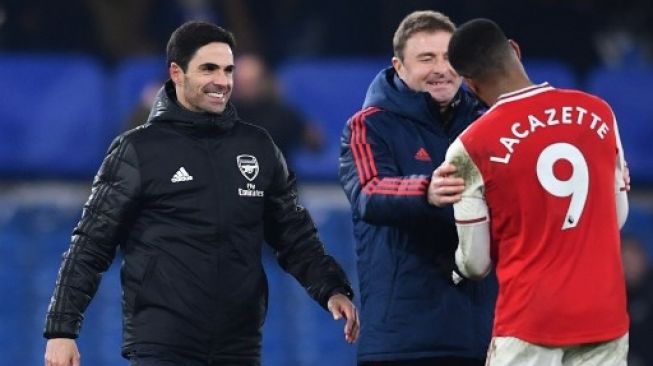 Manajer Arsenal Mikel Arteta (kiri) menghampiri striker Alexandre Lacazette usai pertandingan melawan Chelsea di Stamford Bridge, London. Ben STANSALL / AFP