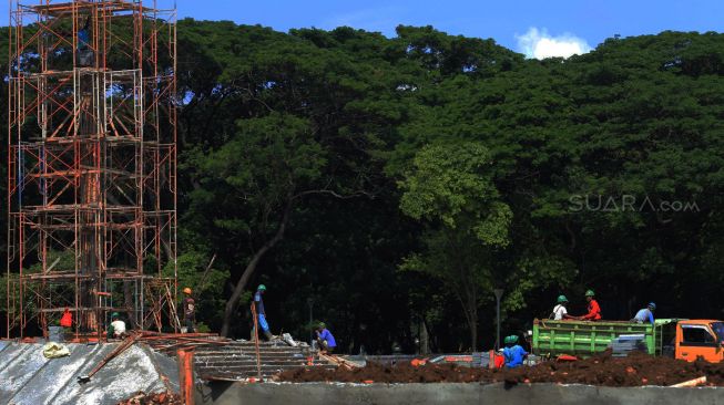 Pekerja mengerjakan proyek revitalisasi taman sisi selatan monumen nasional (Monas), Gambir, Jakarta Pusat, Kamis (23/01). [Suara.com/Alfian Winanto]
