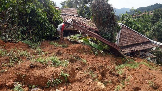 Warga melihat bangunan rusak tertimbun longsor di Kampung Cigobang, Desa Banjarsari, Lebak, Banten, Jumat (24/1). [ANTARA FOTO/Asep Fathulrahman]