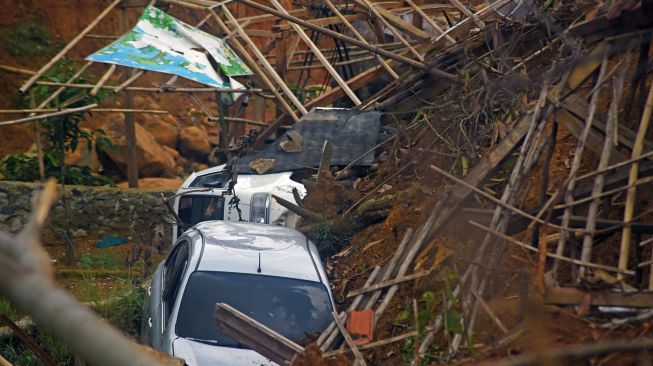 Dua kendaraan dan bangunan dibiarkan rusak setelah tertimbun longsor di Kampung Cigobang, Desa Banjarsari, Lebak, Banten, Jumat (24/1). [ANTARA FOTO/Asep Fathulrahman]