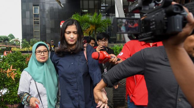 Artis Faye Nicole Jones (kedua kiri) berjalan meninggalkan ruangan usai menjalani pemeriksaan di gedung KPK, jakarta, Jumat (24/01). [ANTARA FOTO/M Risyal Hidayat]