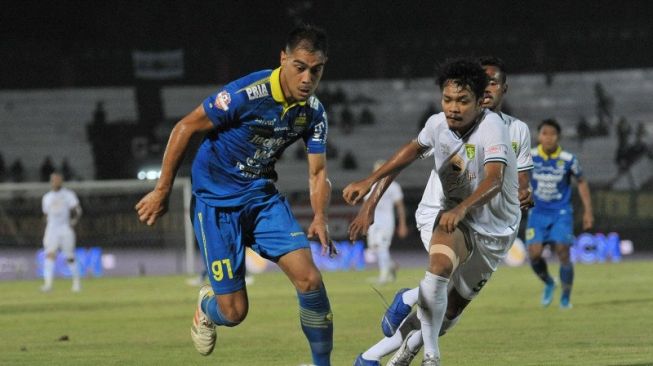 Pesepak bola Persib Bandung Omid Nazari (kiri) menggiring bola dibayangi pesepak bola Persebaya Surabaya Muhammad Hidayat dalam pertandingan sepak bola Liga 1 2019 di Stadion I Wayan Dipta, Gianyar, Bali, Jumat (18/10/2019). ANTARA FOTO/Nyoman Budhiana/wsj.