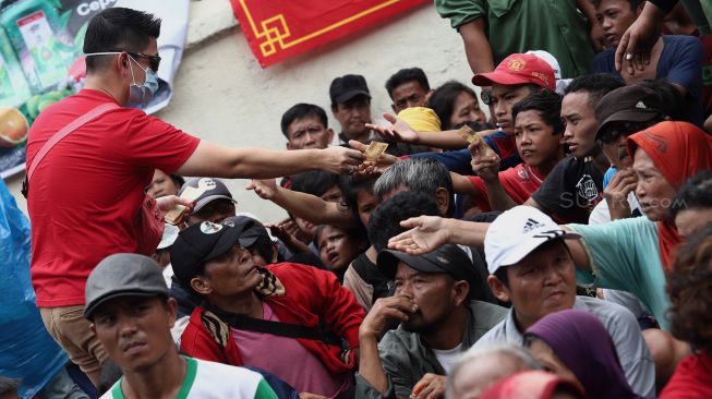 Sejumlah warga dan pengemis musiman menerima angpau di Vihara Dharma Bhakti, Jakarta Barat, Sabtu (25/1). [Suara.com/Angga Budhiyanto]