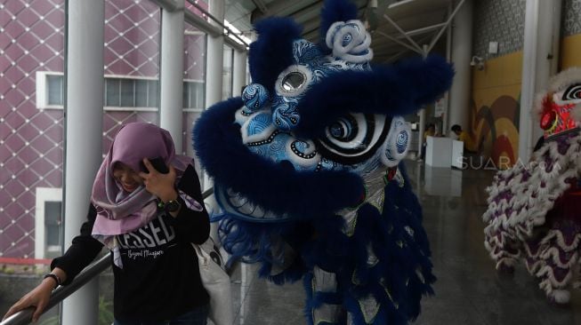 Barongsai menghibur calon penumpang di Stasiun LRT Boulevard Utara, Kelapa Gading, Jakarta Utara, Sabtu (25/1). [Suara.com/Angga Budhiyanto]