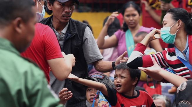 Sejumlah warga dan pengemis musiman menerima angpau di Vihara Dharma Bhakti, Jakarta Barat, Sabtu (25/1). [Suara.com/Angga Budhiyanto]