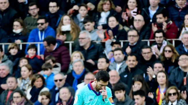 Pemain depan Barcelona Lionel Messi bereaksi selama pertandingan sepak bola liga Spanyol Valencia melawan Barcelona di Stadion Mestalla, Valencia, Spanyol, Sabtu (26/1). [JOSE JORDAN / AFP]